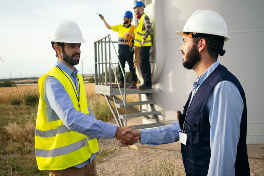 Gestor e técnico dando as mãos em contrato de prestação de serviço