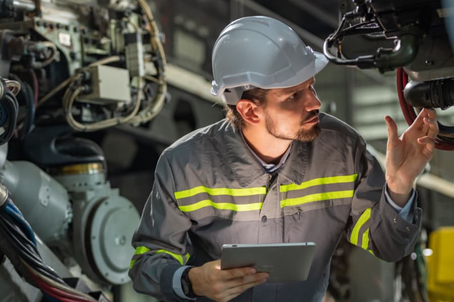 Técnico realizando a manutenção de máquinas industriais