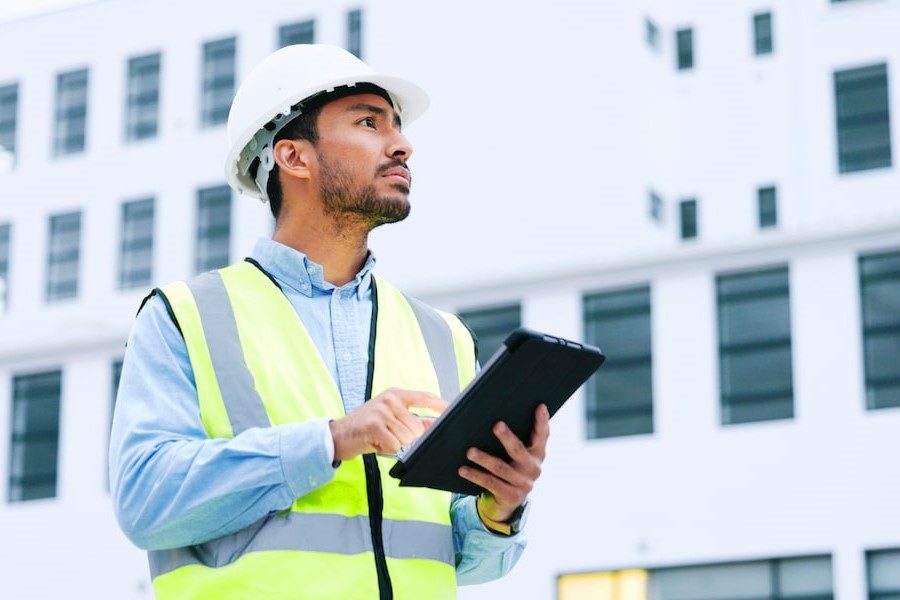 Engenheiro utilizando um software como auxílio na manutenção de edificações.